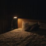 Comodino con lampada accesa in una camera da letto rilassante, routine serale per dormire meglio