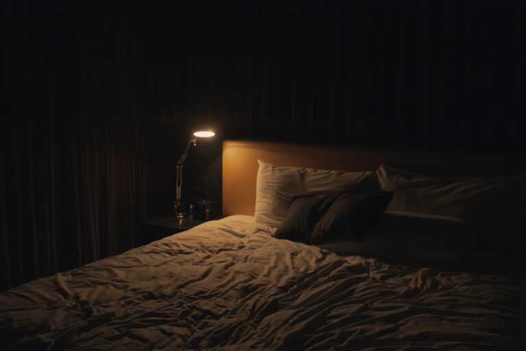 Comodino con lampada accesa in una camera da letto rilassante, routine serale per dormire meglio