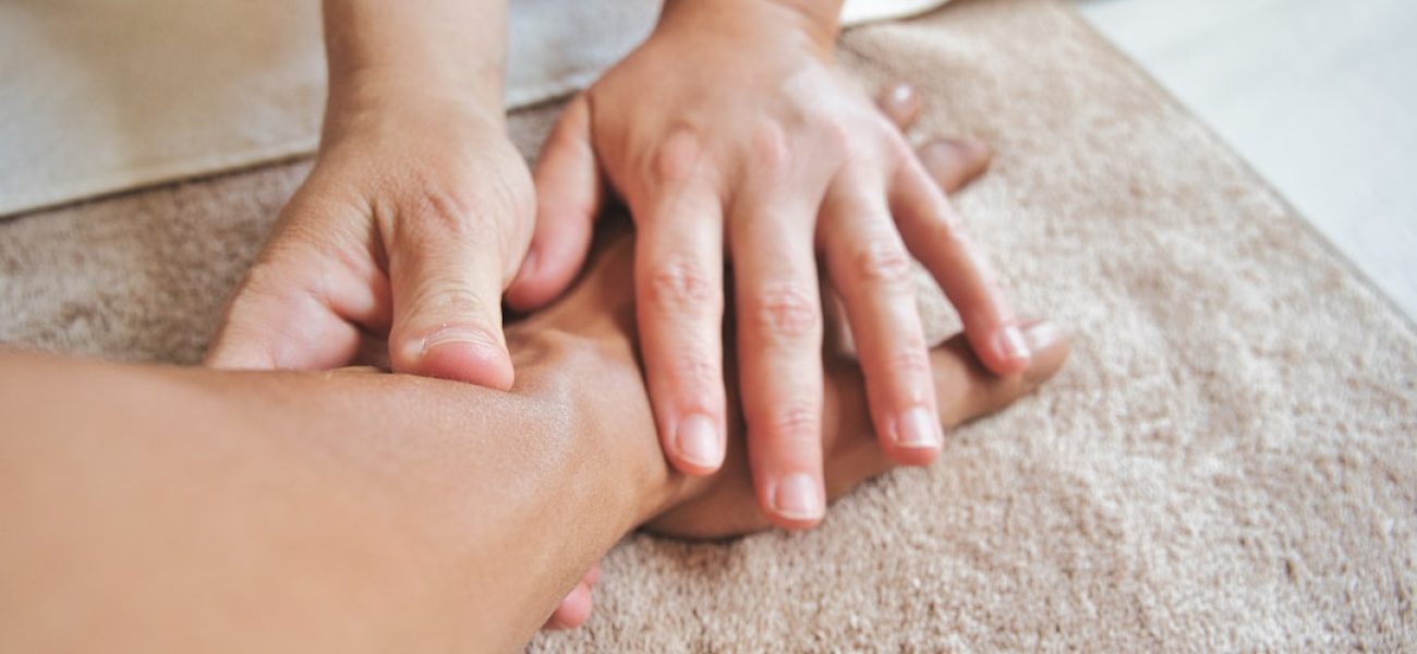 Mano che riceve una pressione delicata sul palmo, trattamento di digitopressione